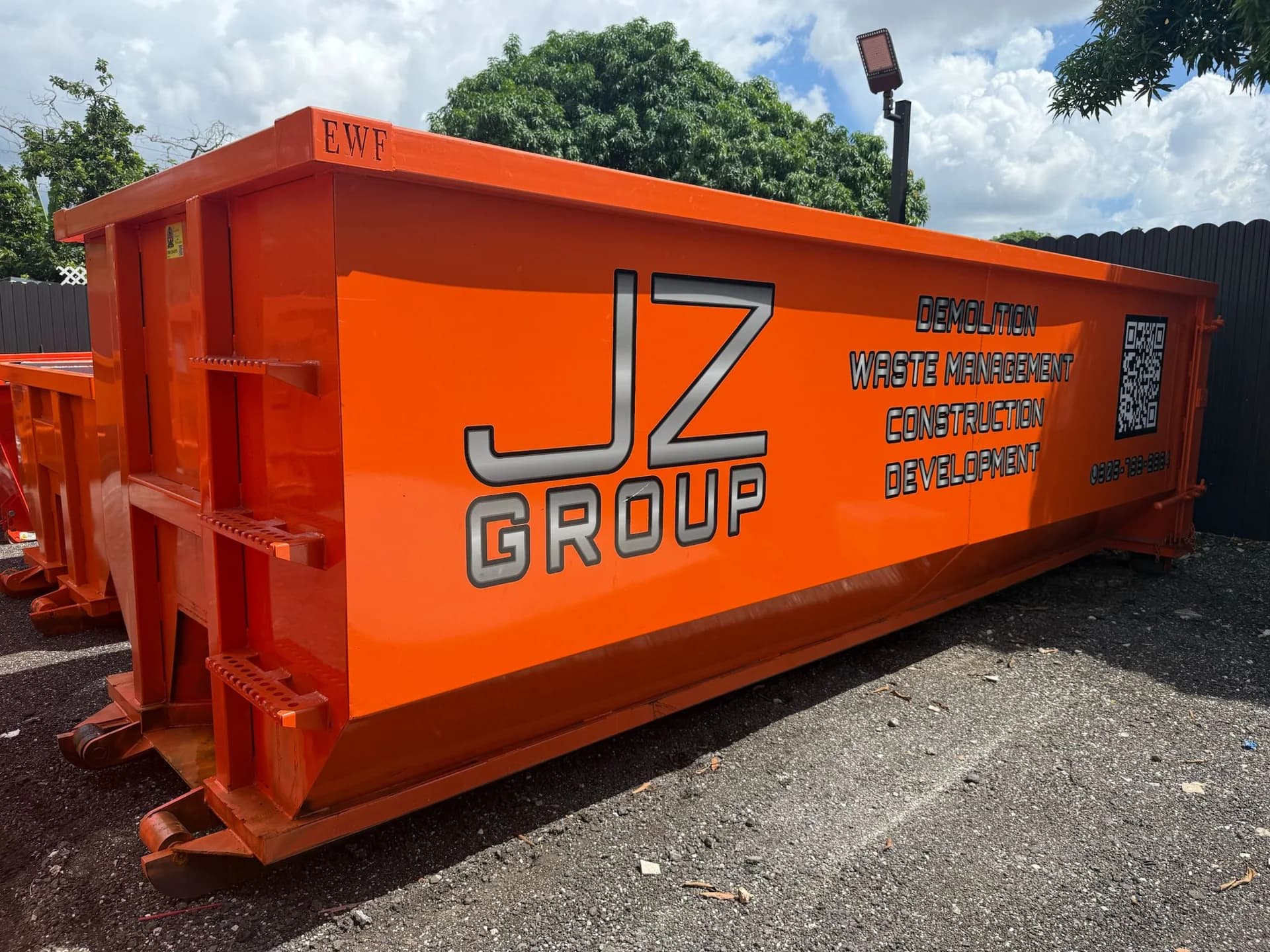 Orange JZ roll-off container photographed from the side and end
